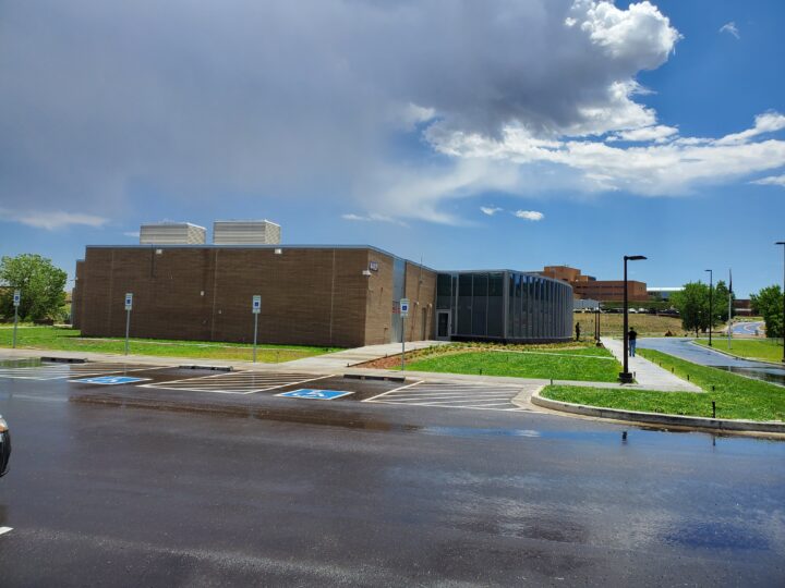 Outside of the medical center, with parking lot and sidewalk.