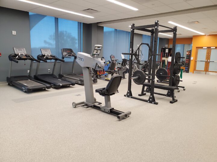 Gym and exercise area with weights, exercise machines, and treadmills. 