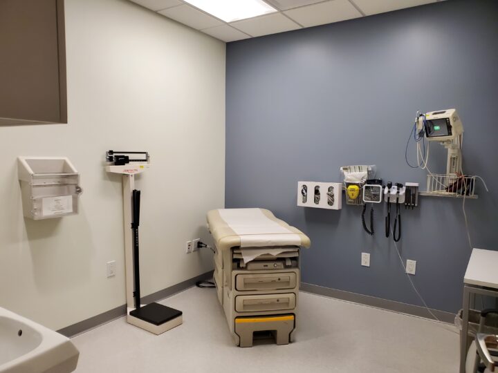 Patient exam room with equipment, scale, and exam table.